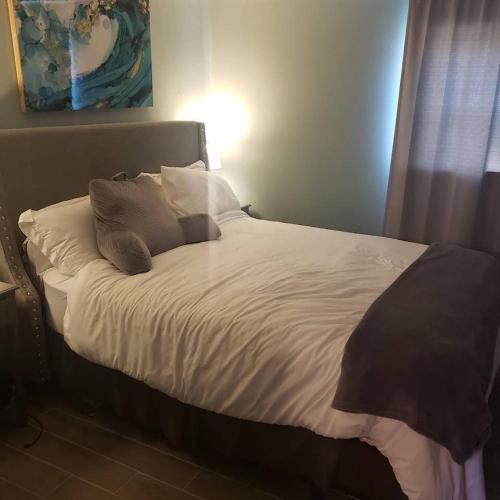 - un lit avec des draps et des oreillers blancs dans une chambre dans l'établissement Halibut House Unit 4, à Seward
