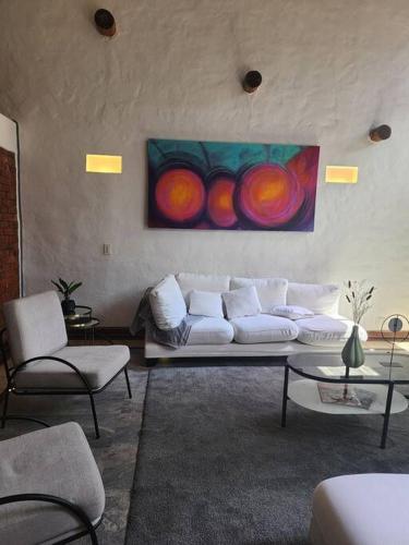 a living room with a white couch and a painting on the wall at Spain style country house in Cajica in Cajicá