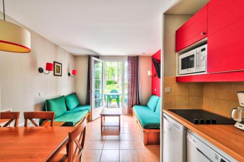 Il comprend une cuisine et un salon doté d'un mobilier vert. dans l'établissement La résidence du Lac - maeva Home - Maison 2 pièces 5 personnes - Sélection MAE-4354, à Monflanquin