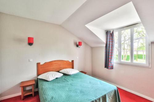 une chambre avec un lit vert et une fenêtre dans l'établissement La résidence du Lac - maeva Home - Maison 2 pièces 5 personnes - Sélection MAE-4354, à Monflanquin