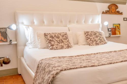 1 dormitorio con 1 cama blanca y 2 almohadas en Tintori art loft, en Florencia