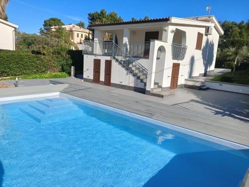 eine Villa mit einem Pool vor einem Haus in der Unterkunft Villa Corallo - Scopello Guidaloca Bay in Scopello