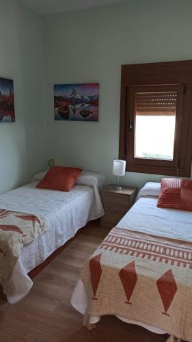 a bedroom with two beds and a window at Casa Alicia in Poio