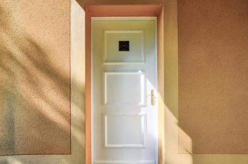 une porte blanche dans l'angle d'une pièce dans l'établissement La résidence du Lac - maeva Home - Maison 2 pièces 5 personnes - Prestige MAE-4734, à Monflanquin