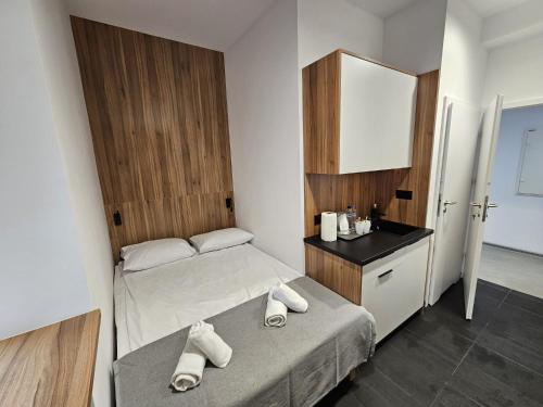 a small bedroom with a bed and a sink at Esperanto Home in Katowice