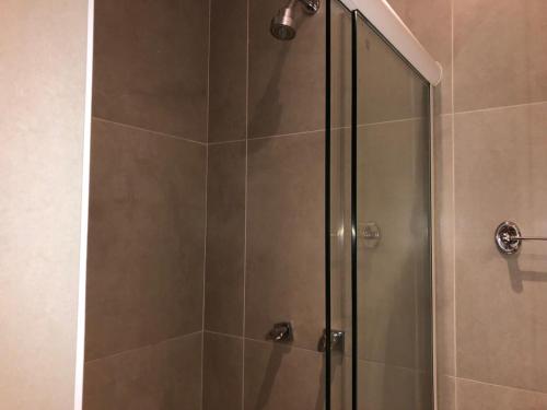 a shower stall with a glass door in a bathroom at Hotel Praia Grande Niterói in Niterói