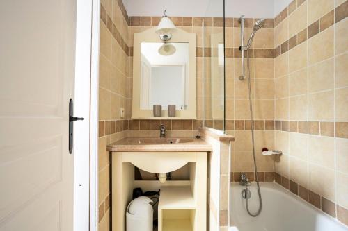 une salle de bain avec un lavabo, une baignoire et un miroir dans l'établissement Village Le Rouret - maeva Home - Maison 2 Pièces 5 Personnes - Sélection MAE-6354, à Grospierres