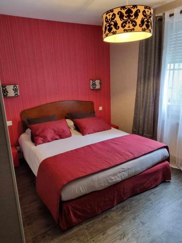 a bedroom with a large bed with red walls at Le Pigeonnier in Saint-Martin-le-Beau