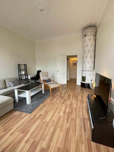 - un salon avec un canapé et une télévision dans l'établissement Rentalux Apartments at Nybrogatan, à Sundsvall