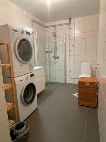 a washing machine in a bathroom with a shower at Rentalux Apartments at Nybrogatan in Sundsvall