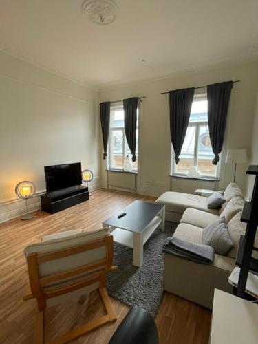 Rentalux Apartments at Nybrogatan في سوندسفال: غرفة معيشة مع أريكة وطاولة