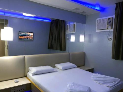 um quarto de hospital com duas camas e um espelho em Hotel Praia Grande Niterói em Niterói