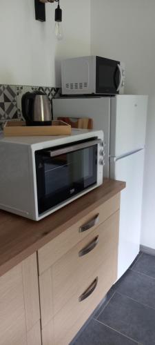 a microwave oven sitting on top of a kitchen counter at Gite clos masure Blévillot in Saint-Gilles-de-la-Neuville