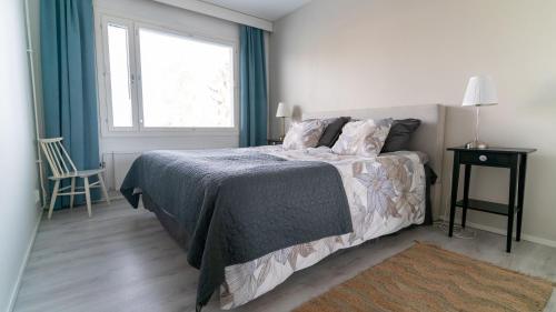 um quarto com uma cama, uma janela e uma cadeira em Spacious 68m2 apartment with fabulous forest view em Järvenpää