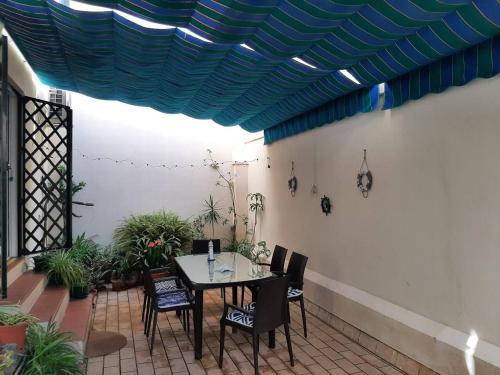 un patio con mesa y sillas y un techo azul en 2 bedrooms apartement at Cadiz 450 m away from the beach with furnished terrace and wifi, en Cádiz