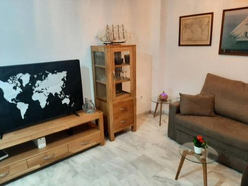 sala de estar con sofá y TV de pantalla plana en 2 bedrooms apartement at Cadiz 450 m away from the beach with furnished terrace and wifi, en Cádiz