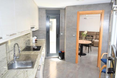 a kitchen with a sink and a table at Alojamientos Yecla Centro by Casa de la Feria del Mueble Yecla in Yecla