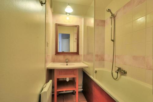 une salle de bain avec un lavabo, une baignoire et un miroir dans l'établissement La résidence du Lac - maeva Home - Appartement 2 pièces 5 personnes - Sélection MAE-5524, à Monflanquin