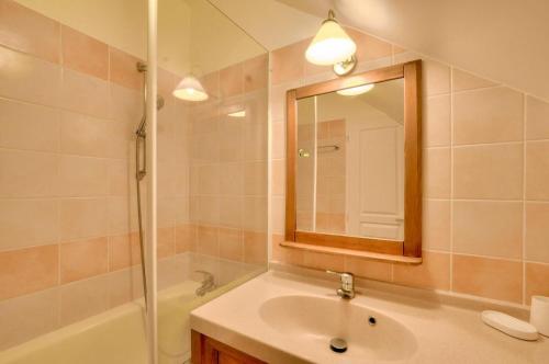 une salle de bain avec un lavabo, une baignoire et un miroir dans l'établissement La résidence du Lac - maeva Home - Appartement 2 pièces 5 personnes - Confort MAE-5544, à Monflanquin