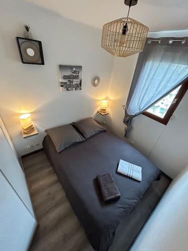 - une chambre avec un lit dans une chambre avec deux lampes dans l'établissement La voile au Lamparo - T2 climatisé - parking, à Port-Leucate