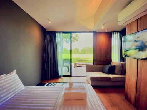 Ban Pa LanにあるIdeal View Villa lannaのリビングルーム(ベッド1台、ソファ付)