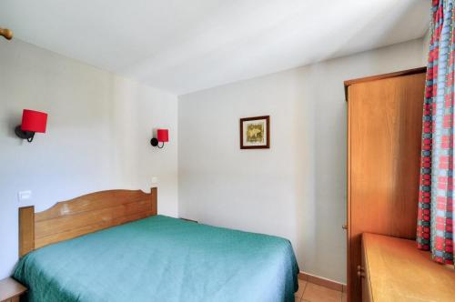 une petite chambre avec un lit et une chaise dans l'établissement La résidence du Lac - maeva Home - Appartement 2 pièces 5 personnes - Sélection MAE-5614, à Monflanquin