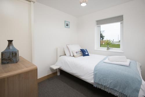 a white bedroom with a bed and a window at 3 Bed in Belford oc-cn065 in Belford