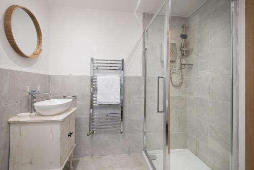 a bathroom with a shower and a sink and a mirror at 3 Bed in Belford oc-cn065 in Belford
