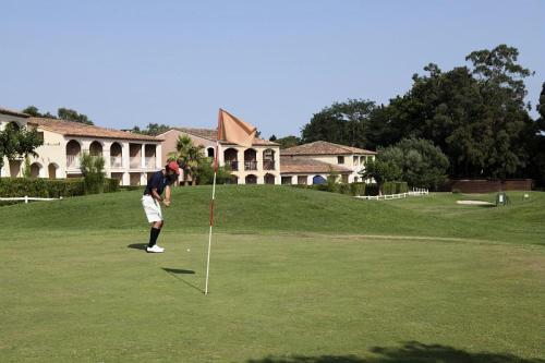 uma pessoa está a jogar golfe num putting green em Résidence Les Parcs de Grimaud - maeva Home - Appartement 3 pièces 6 perso 804 em Grimaud