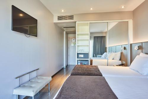 a hotel room with a bed and a tv at Silken Turcosa 3 Sup in Castellón de la Plana