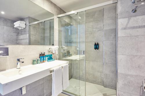 a bathroom with a sink and a shower at Silken Turcosa in Castellón de la Plana