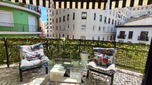 einen Balkon mit einem Glastisch und 2 Stühlen in der Unterkunft Terrasa de Mercado Central in Valencia