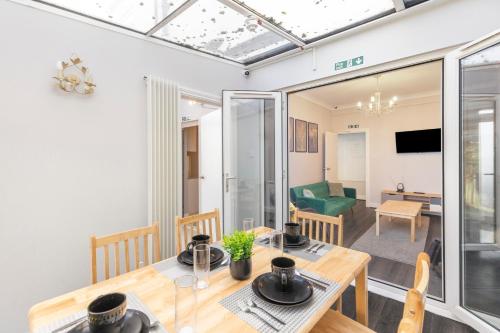 a dining room and living room with a table and chairs at Chrystal Palace Stays with free parking Lambeth in Upper Norwood