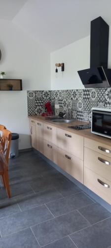 a kitchen with a sink and a microwave at Gite clos masure Blévillot in Saint-Gilles-de-la-Neuville