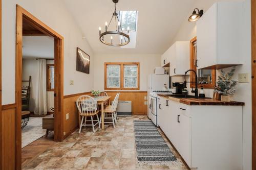 a kitchen with a table and a white refrigerator at EverHaus Cabin by the Brook - Harvard Brook Cabins in Lincoln