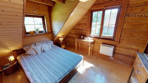 a bedroom with a bed in a log cabin at Dom z Widokiem in Piwniczna-Zdrój