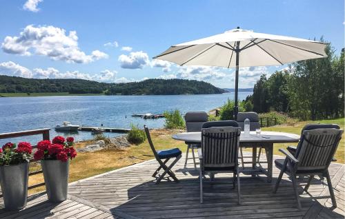 a patio with a table and chairs and an umbrella at Three-Bedroom Holiday Home In Brastad in Brastad