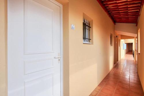 une porte blanche dans un couloir dans l'établissement Village Pont Royal en Provence - maeva Home - Appartement 2 pièces 4 personnes - Confort MAE-7164, à Mallemort