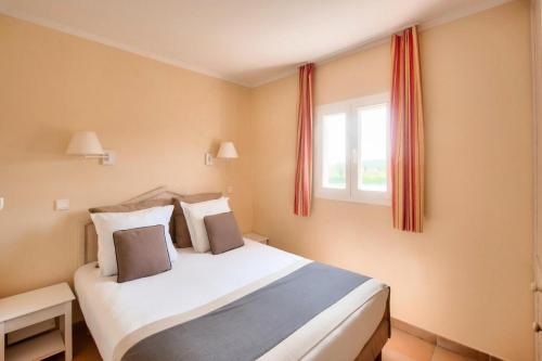 Schlafzimmer mit einem Bett und einem Fenster in der Unterkunft Village Pont Royal en Provence - maeva Home - Appartement 2 pièces 6 person 034 in Mallemort