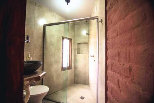 a bathroom with a shower with a toilet and a sink at Daya Ma Hospedagem in Alto Paraíso de Goiás