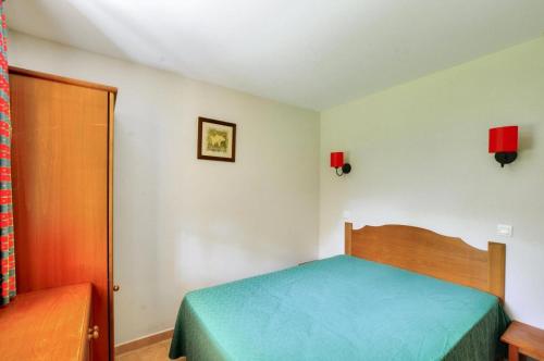 - une chambre avec un lit doté d'un couvre-lit bleu dans l'établissement La résidence du Lac - maeva Home - Appartement 2 pièces 5 personnes - Conf 454, à Monflanquin