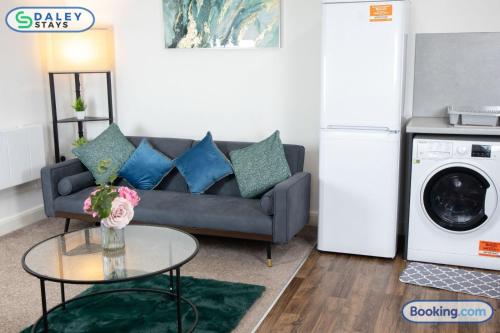 a living room with a couch and a washing machine at Failsworth large Apartment- free gated parking by Daley Stays in Manchester