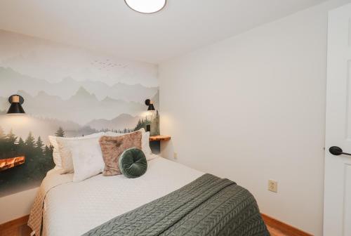 a bedroom with a bed with a painting on the wall at EverHaus Cabin by the Brook - Harvard Brook Cabins in Lincoln