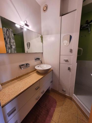 La salle de bains est pourvue d'un lavabo, d'un miroir et d'une douche. dans l'établissement Le Birdy - maeva Home - Appartement 2 pièces 4 personnes - Prestige 614, à La Grande Motte