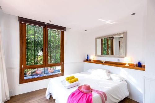 Villa Jazminez by Villa Plus في مربلة: غرفة نوم بيضاء بها سرير ونافذة