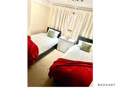 a bedroom with two beds and a window at Spacious 3-Bed House with free parking in Hornchurch
