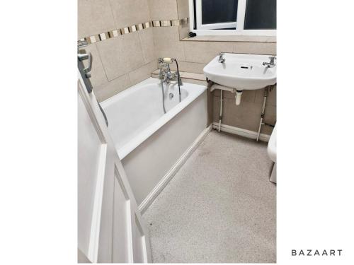 bagno con vasca e lavandino di Spacious 3-Bed House with free parking a Hornchurch