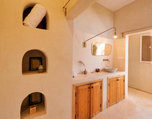 a bathroom with a sink and a mirror at The Gardener's House, Petit déjeuner inclus in Marrakesh