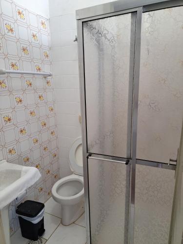 a bathroom with a toilet and a glass shower stall at Grande Hotel Torres in Torres