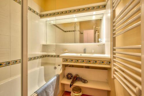 łazienka z wanną, umywalką i lustrem w obiekcie Village Pont Royal en Provence - maeva Home - Appartement cosy et climatisé 2 pièces 5 personnes avec jardin - Prestige - super Home MAE-2864 w mieście Mallemort